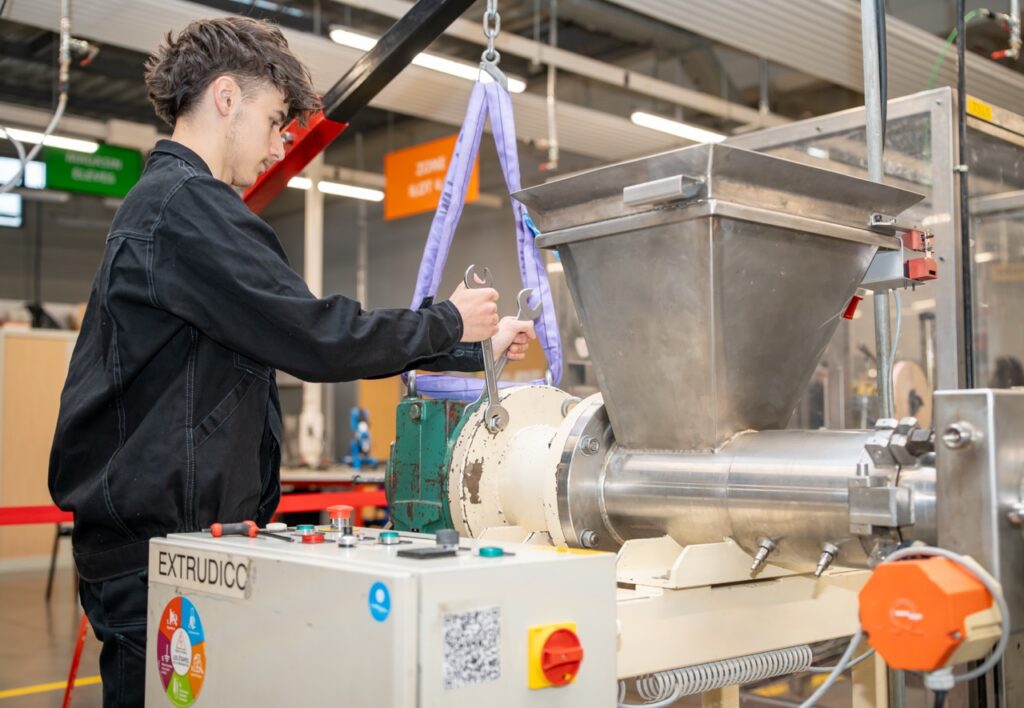Eleve serrant un raccord sur une machine du plateau de maintenance