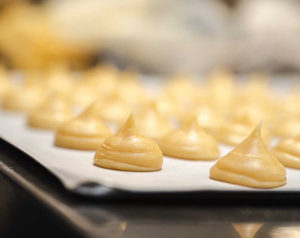 Choux a la creme alignes sur une plaque de cuisson